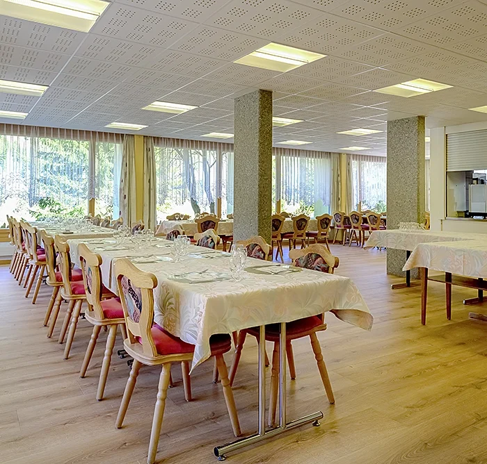 Grosszügiger Essraum mit Holzboden, vielen Fenstern und viel Platz für Tische und Stühle.